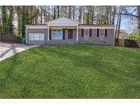 Charming brick home featuring a spacious front yard with a manicured lawn at 2350 Brenda Se Dr, Smyrna, GA 30080