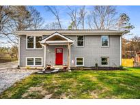 Charming gray brick home featuring a bright red front door and well-manicured lawn at 2831 Spruce Point Rd, South Fulton, GA 30349