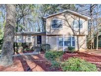 Two-story home with neutral siding, neat landscaping, and a inviting front entrance with ironwork at 1037 Martin Rd, Stone Mountain, GA 30088