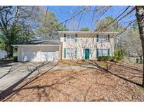 Charming two-story home featuring a two-car garage, green shutters, and a well-maintained front yard at 4401 Shiloh Hills Dr, Snellville, GA 30039