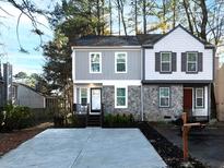 Charming two-story townhome features a mix of stone and siding, new concrete drive, and fresh landscaping at 355 Pleasant Oak Sw Ct, Marietta, GA 30008