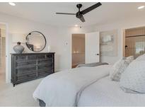A soothing main bedroom showcasing a dresser with round mirror and ceiling fan at 4814 Floydwood Ln, Mableton, GA 30126