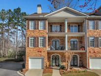 Brick townhome featuring a private entry, a garage, and private outdoor balconies on multiple levels at 2599 Oglethorpe Ne Cir, Brookhaven, GA 30319