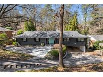 Ranch-style house with charcoal exterior, light blue front door, and driveway leading to a carport at 3240 Pinestream Nw Rd, Atlanta, GA 30327