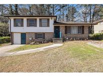 Charming two-story home featuring a brick facade and well-manicured lawn at 989 Queen Elizabeth Way, Morrow, GA 30260