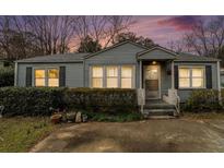 Charming single-story home with blue siding and landscaped front yard and an inviting front porch at 1054 Shepherds Ne Ln, Atlanta, GA 30324