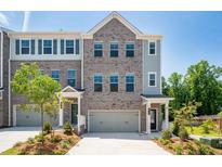 Charming townhome with a two-car garage, attractive brickwork, and a well-maintained front yard at 1745 Lansmere Sw St, Marietta, GA 30008