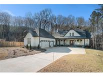 Charming home featuring a spacious driveway leading to a three-car garage and a welcoming front porch at 2312 Allison Way, Loganville, GA 30052