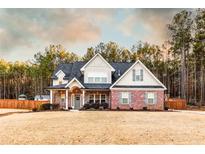 Charming two-story home with a brick facade, covered porch, and professionally landscaped yard at 35 Rock Rose Dr, Covington, GA 30014