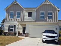 Charming two-story home with a well-maintained lawn and a modern white Range Rover parked in the driveway at 60 Cottontail Lane, Villa Rica, GA 30180