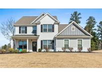 Charming two-story home with white brick and siding, black shutters, and a welcoming front porch at 6801 Louis Dr, Locust Grove, GA 30248