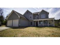 Charming two-story home with a covered front porch and a two-car garage, set on a spacious lawn at 70 Woodcliff Way, Covington, GA 30014