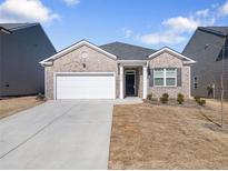 Charming single-story brick home with a two-car garage and well-maintained lawn at 2030 Vidalia Ct, Dacula, GA 30019