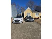 Charming yellow townhome with space for two cars in the driveway at 6424 W Charter Way, Lithonia, GA 30058
