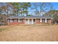 Charming single-story brick home featuring a welcoming front porch and well-maintained landscaping at 999 Chestnut Oak Ct, Lawrenceville, GA 30046