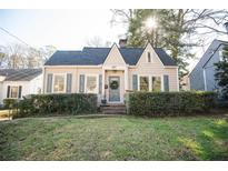 Charming home with manicured lawn and neutral siding complemented by grey shutters and inviting front entrance at 981 Church St, Decatur, GA 30030