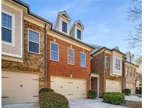 A charming brick townhome featuring an attached garage and manicured landscaping at 10416 Park Walk Pt, Alpharetta, GA 30022