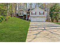 Charming two-story home with a two-car garage and a well-manicured lawn at 305 Bridgewater Ter, Canton, GA 30115