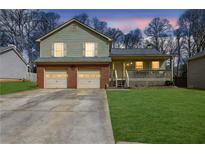 Charming two-story home with a well-maintained lawn, a two-car garage, and inviting front porch at 618 Jenmarie Sw Dr, Mableton, GA 30126