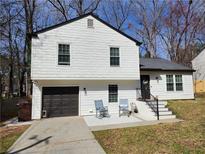 Charming two-story home with white siding, black trim, and a well-maintained front yard at 11250 Bramshill Dr, Johns Creek, GA 30022