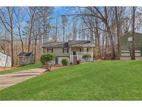 Charming home with green lawn, mature trees and two-car garage in wooded setting at 2401 Westland Way, Acworth, GA 30102