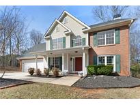 Charming two-story home with brick and siding, a well-manicured lawn, and a welcoming front porch at 1007 Crown River Pkwy, Mcdonough, GA 30252
