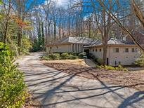 Contemporary ranch-style home featuring a long, private driveway and meticulously landscaped front yard with mature trees at 2153 Starfire Drive Ne Dr, Atlanta, GA 30345