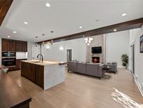 Open-concept living room featuring a kitchen island, fireplace, and hardwood floors at 2153 Starfire Drive Ne Dr, Atlanta, GA 30345