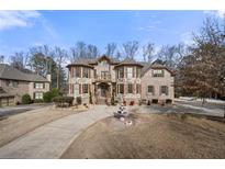 Impressive stone home featuring a fountain, manicured landscaping, and a private driveway at 3017 Canton Pines, Marietta, GA 30068