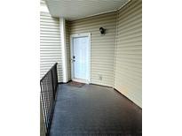 A clean white front door with a black door knocker, set inside a beige building with dark gray concrete at 1349 Orchard Park Dr, Stone Mountain, GA 30083