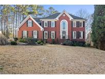 Beautiful brick home with black shutters, arched entryway, and well-manicured landscaping at 1701 Crowes Lake Ct, Lawrenceville, GA 30043