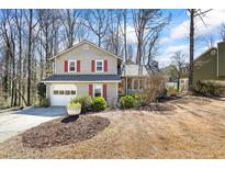 Charming two-story home with a well-maintained front yard and attached garage in a wooded neighborhood at 6038 Maryjo Ln, Norcross, GA 30093