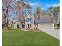 Charming home with manicured lawn, two-car garage, and welcoming front entrance at 149 N Lakeside Nw Dr, Kennesaw, GA 30144