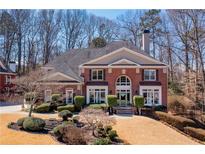 Stately brick home with a manicured front lawn and mature trees at 3410 Kates Way, Duluth, GA 30097