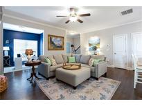 Inviting living room featuring a comfortable sectional sofa, stylish decor, and hardwood floors at 7738 Fawn Cir, Covington, GA 30014