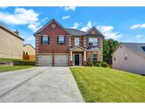 Traditional brick home with a well-manicured lawn, two-car garage, and inviting entrance at 9710 Rabun Way, Jonesboro, GA 30238