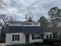 Quaint one-story home with a unique architectural design and dark shutters on a cloudy day at 1867 Dresden Dr, Atlanta, GA 30319