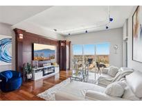 Bright living room features hardwood floors, fireplace, entertainment center, and sliding glass doors to a balcony at 4561 Olde Perimeter Way # 2609, Atlanta, GA 30346