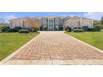 Stunning home featuring a large brick driveway, manicured lawn, and grand entrance with a portico at 525 Waters Way, Fayetteville, GA 30215