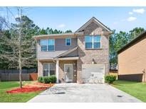 Charming two-story home with a well-maintained front yard and a combination brick and siding exterior at 5884 Grande River Rd, Atlanta, GA 30349