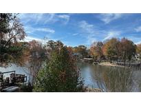 Scenic lake view with a dock and colorful autumn trees against a blue sky at 2820 Skye Ter, Duluth, GA 30096
