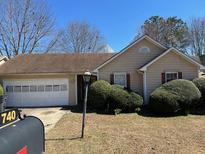 Charming single story home with a two car garage and a manicured front lawn at 740 Kibbe Cir, Lawrenceville, GA 30044