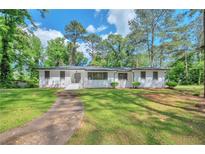 Charming one-story home with a well-manicured lawn and inviting walkway, surrounded by mature trees at 1332 Willis Mill Sw Rd, Atlanta, GA 30311