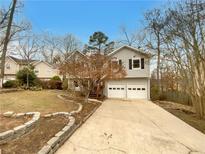 Charming split-level home featuring a two-car garage and landscaped front yard at 832 Overlook Trl, Canton, GA 30115