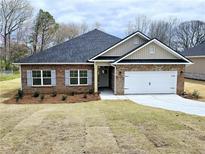 Charming brick home with a two-car garage and professionally landscaped front yard at 112 Scarlett Place Dr, Bowdon, GA 30108