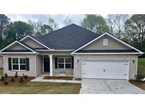Charming single-story brick home featuring a two-car garage and well-maintained front yard at 116 Scarlett Place Dr, Bowdon, GA 30108