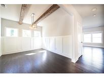 Bright dining room featuring dark wood floors, board and batten wainscoting, rustic wood beam ceiling and modern light fixture at 2076 Greenridge Se Rd, Smyrna, GA 30080