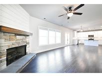 Bright living room with a stone fireplace, hardwood floors, and a ceiling fan at 2076 Greenridge Se Rd, Smyrna, GA 30080