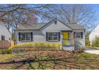 Charming gray bungalow with a bright yellow door and a cozy front yard with mature trees at 679 Blake Se Ave, Atlanta, GA 30316