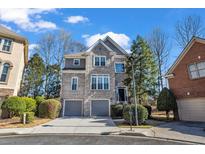 Beautiful two-story home with brick and stone exterior and two car garage on a sunny day at 1129 Gavinwood Pl, Decatur, GA 30033